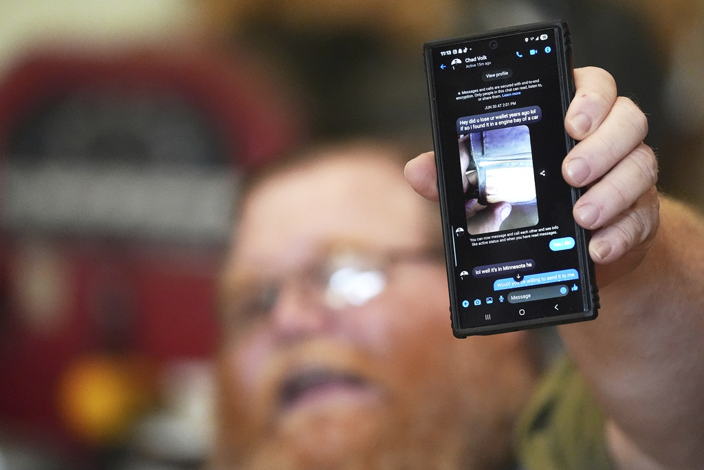 Richard Guilford holds up a chat message he received from Chad Volk during an interview Thursday, Aug. 14, 2025, in Petersburg, Mich. (AP Photo/Ryan Sun)