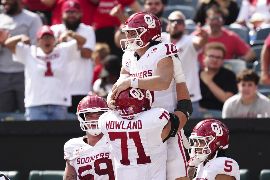 Oklahoma quarterback John Mateer (10) celebrates his touchdown with Logan Howland during the second half of an NCAA college football game against Temple, Saturday, Sept. 13, 2025, in Philadelphia. (AP Photo/Derik Hamilton)
