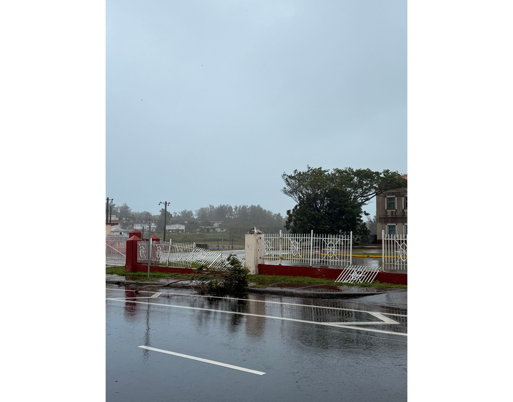 Portions of the gate fronting Tamuning Elementary School, in Tamuning, Guam, have broken off as Super Typhoon Sinlaku's outer bands pass through the island, Tuesday, April 14, 2026. (Eric Rosario/Kandit News via AP)