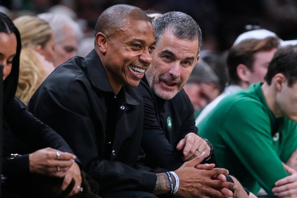 Boston Celtics owner Bill Chisholm, center right, talks with former Celtics guard Isaiah Thomas, center left, during the first half of an NBA basketball game against the Miami Heat, Friday, Dec. 19, 2025, in Boston. (AP Photo/Charles Krupa)