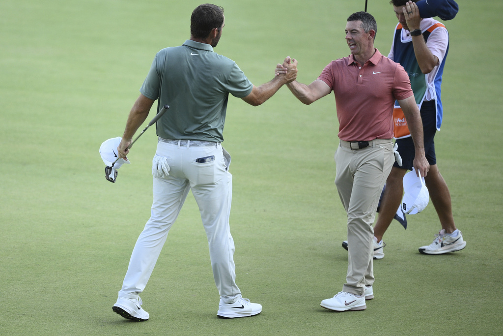 Rory McIlroy, right, of Northern Ireland, shakes hands with Scottie Scheffler, left, after they finished their second round of the BMW Championship golf tournament at Caves Valley Golf Club, Friday, Aug. 15, 2025, in Owings Mills, Md. (AP Photo/Nick Wass)