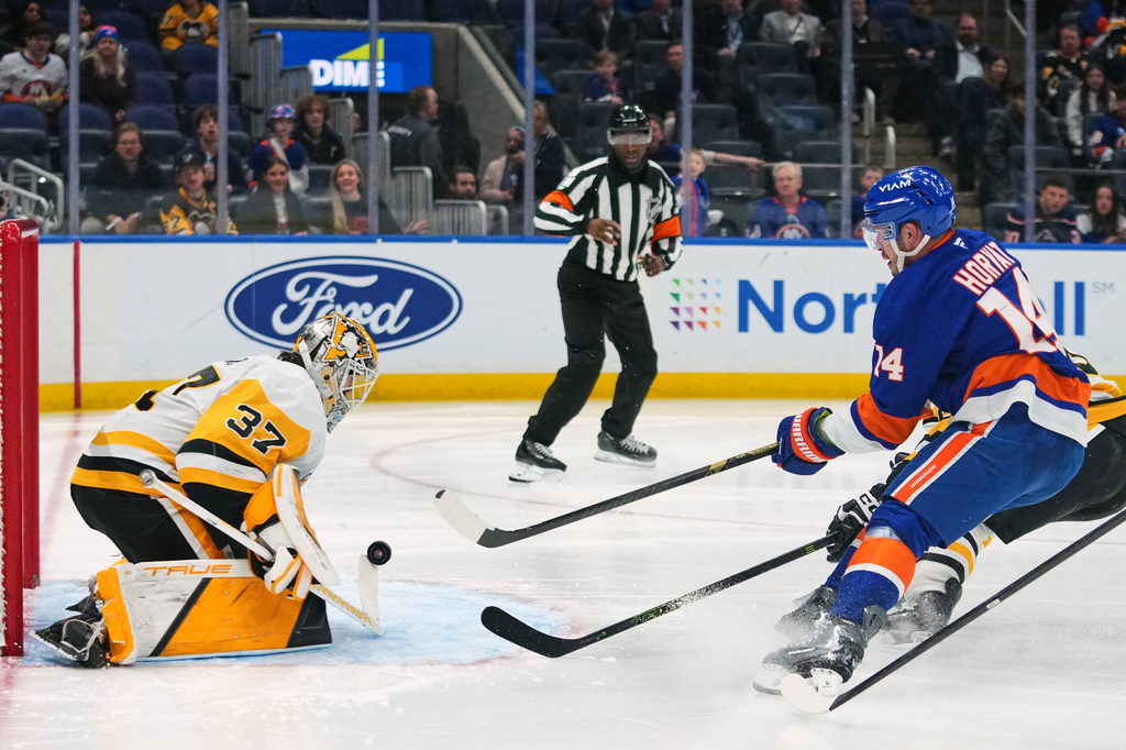 Pittsburgh Penguins goaltender Arturs Silovs (37) stops a shot by New York Islanders' Bo Horvat (14) during the second period of an NHL hockey game Monday, March 30, 2026, in Elmont, N.Y. (AP Photo/Frank Franklin II)