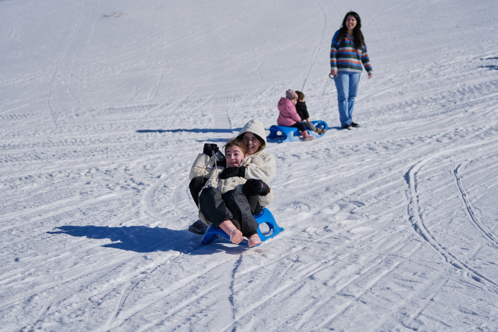 Families enjoy sledding in the snow at the Mzaar-Kfardebian ski resort northeast of Beirut, Lebanon, Saturday, Jan. 3, 2026. (AP Photo/Hassan Ammar)