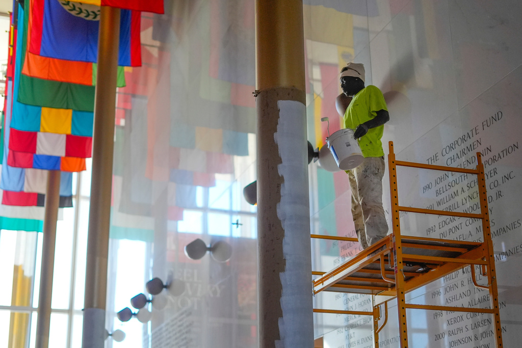 FILE - Odden Shaw paints over a gold colored column inside the Hall of Nations at the Kennedy Center for Performing Arts in Washington, Oct. 24, 2025, in preparation for upcoming FIFA World Cup 2026 Final Draw. (AP Photo/Pablo Martinez Monsivais, file)