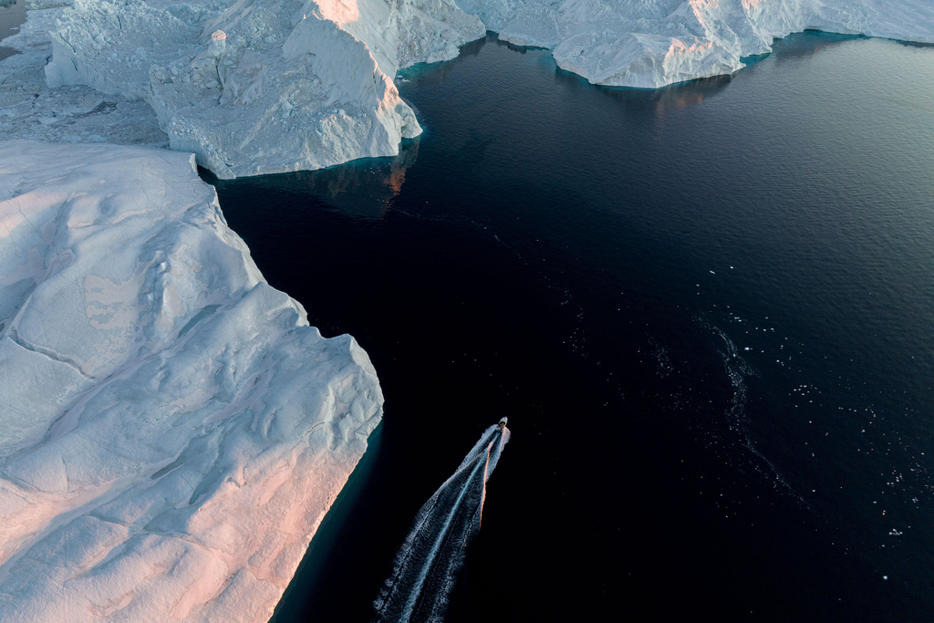 A fishing boat rides in front of an iceberg at Disko Bay near Ilulissat, Greenland, on Wednesday, Jan. 28, 2026. (AP Photo/Evgeniy Maloletka)