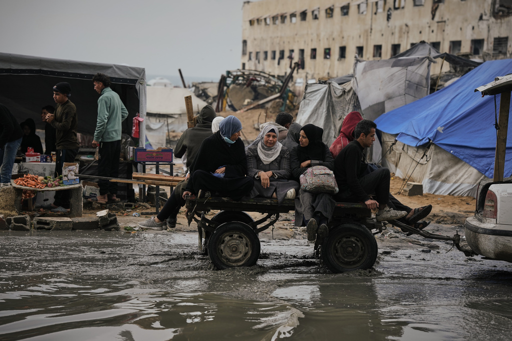Palestinians ride in a cart pulled by a vehicle through a flooded street after stormy weather in Gaza City Wednesday, Dec. 10, 2025. (AP Photo/Jehad Alshrafi)