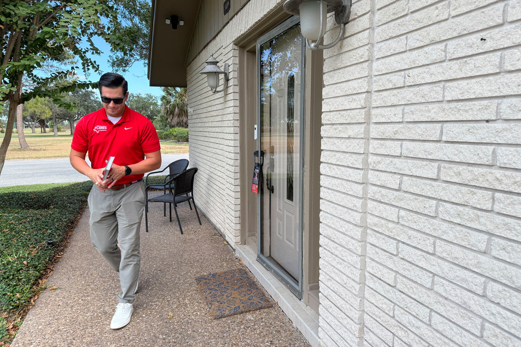 This photo taken with a smartphone shows Republican U.S. House candidate Eric Flores door knocks on Sunday, Sept. 18, 2026, in Harlingen, Texas. (AP Photo/Jesse Bedayn)