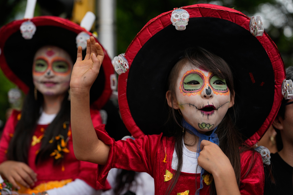 FILE - Girls wave to performers during the World Cup parade in Mexico City, June 13, 2026. (AP Photo/Ricardo Mazalan, File)