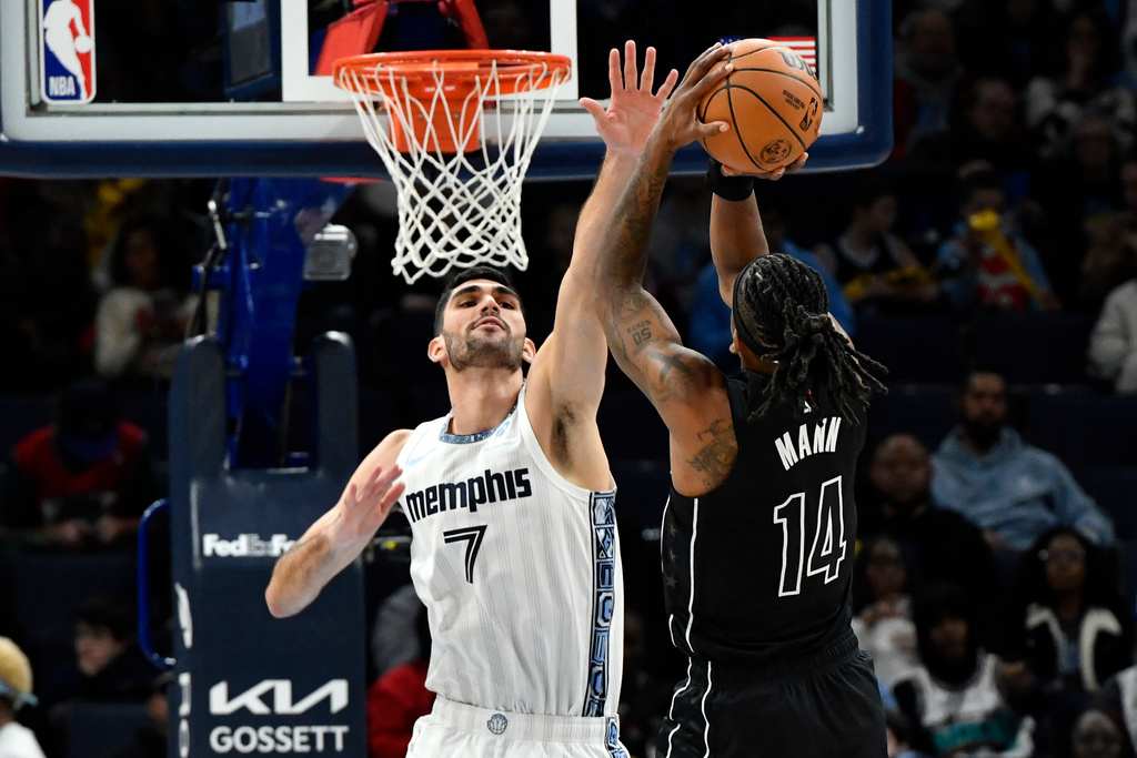 Memphis Grizzlies forward Santi Aldama (7) defends Brooklyn Nets guard Terance Mann (14) in the first half of an NBA basketball game, Sunday, Jan. 11, 2026, in Memphis, Tenn. (AP Photo/Brandon Dill)