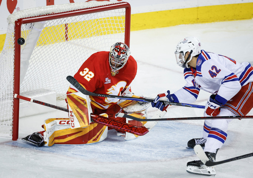 New York Rangers' Noah Laba, right, hits the goal post with the puck as Calgary Flames goalie Dustin Wolf guards the net during second-period NHL hockey game action in Calgary, Alberta, Sunday, Oct. 26, 2025. (Jeff McIntosh/The Canadian Press via AP) New York Rangers' Noah Laba, right, hits the goal post with the puck as Calgary Flames goalie Dustin Wolf guards the net during second-period NHL hockey game action in Calgary, Alberta, Sunday, Oct. 26, 2025. (Jeff McIntosh/The Canadian Press via AP)