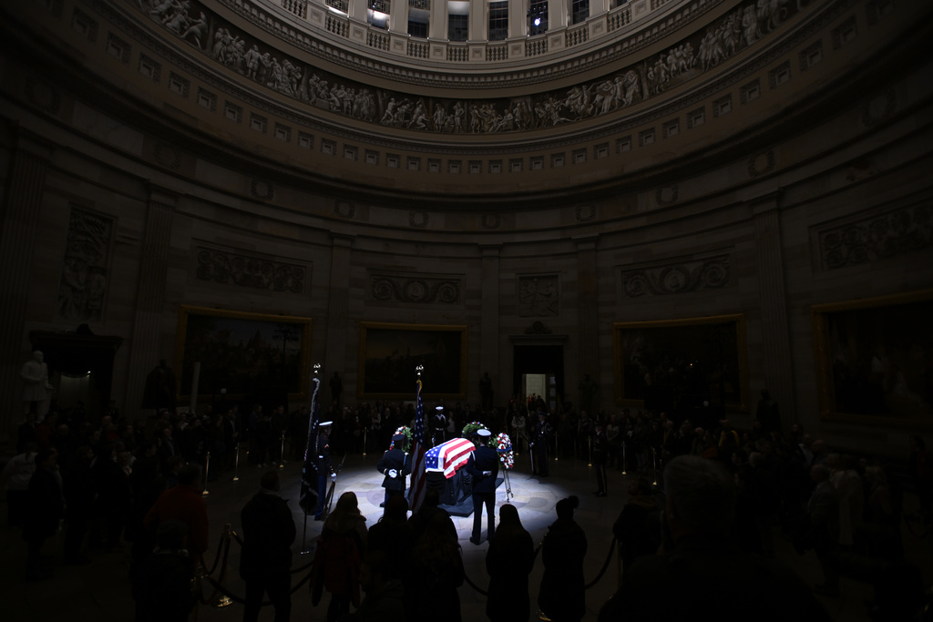 A spotlight iluminates the flag-draped casket to pay tribute toformer President Jimmy Carter as he lies in state at the Rotunda of the U.S. Capitol on Tuesday, Jan. 7, 2025, in Washington. (AP Photo/John McDonnell)