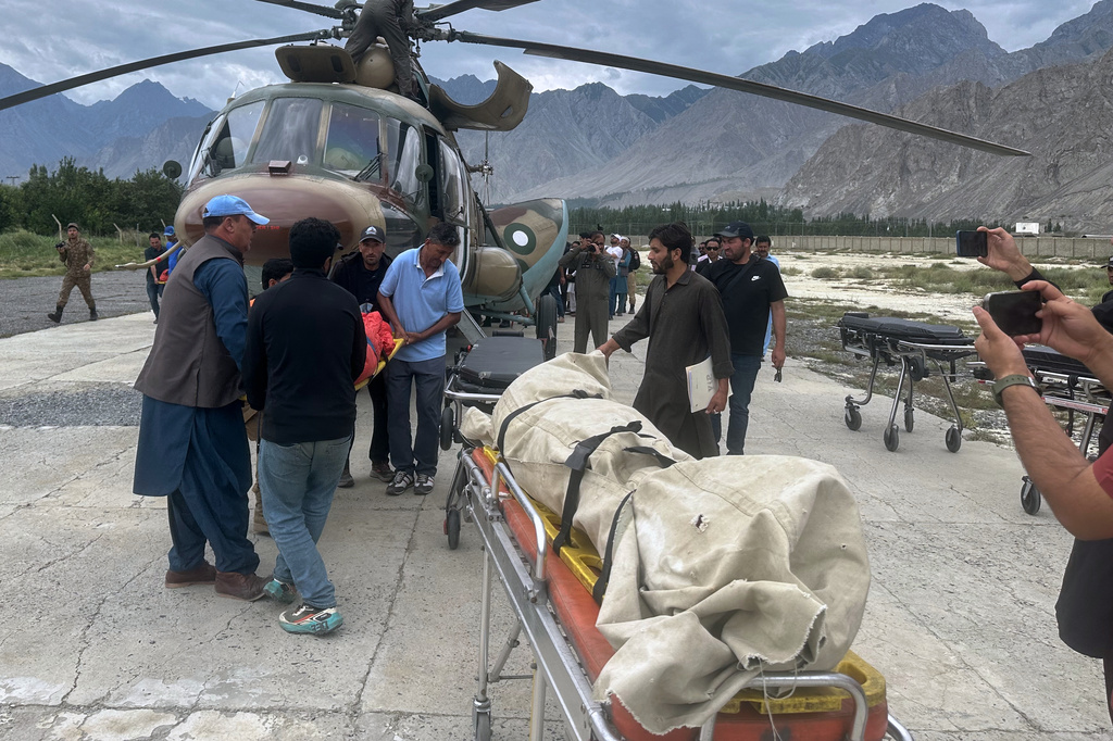 Pakistani army soldiers and volunteers unload from a helicopter the bodies of climbers, that were recovered from Broad Peak nearly a week after an avalanche swept away a 10-member international expedition, upon arrival at a military base in Skardu, in northern Pakistan, Thursday, Aug. 6, 2026. (AP Photo/ M.H. Balti)