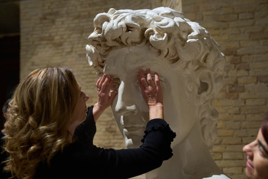 Stefania Terre, who is blind, touches a life-size reproduction of the head of Michelangelo's David during a visit to the Omero Tactile Museum in Ancona, Italy, Thursday, Jan. 15, 2026. (AP Photo/Alessandra Tarantino)