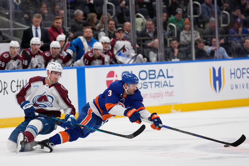 Colorado Avalanche's Brock Nelson, left, and New York Islanders' Adam Pelech dive for the puck during the second period of an NHL hockey game, Thursday, Dec. 4, 2025, in Elmont, N.Y. (AP Photo/Seth Wenig)