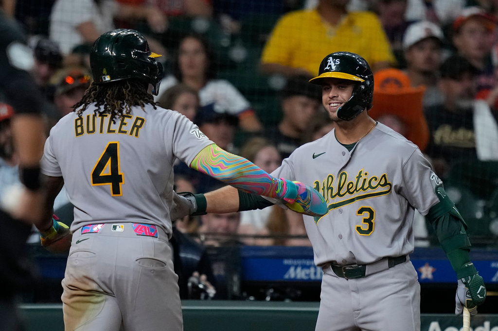 Athletics' Lawrence Butler (4) is congratulated by Max Muncy (3) after scoring during the eighth inning of a baseball game against the Houston Astros, Saturday, Aug. 22, 2026, in Houston. (AP Photo/Kevin M. Cox)