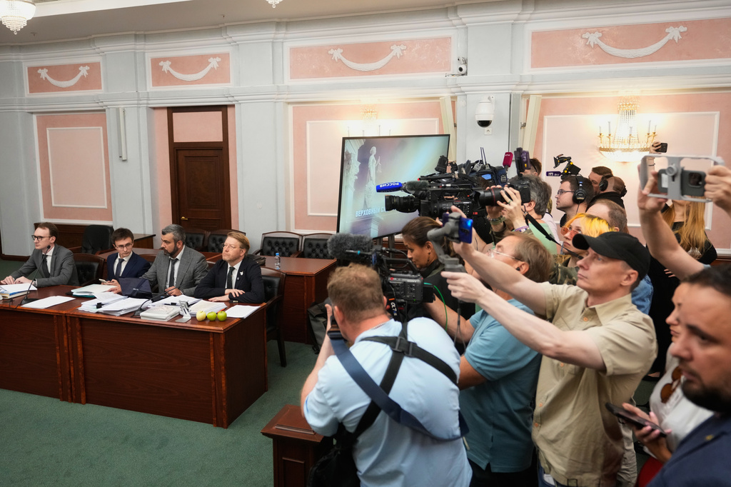 Yabloko party leader Nikolai Rybakov, right at the table, and his lawyers, left of him, attend a hearing on a lawsuit to bar the party from the upcoming parliamentary elections, at the Russia's Supreme Court, in Moscow, Monday, Aug. 10, 2026. (AP Photo/Pavel Bednyakov)