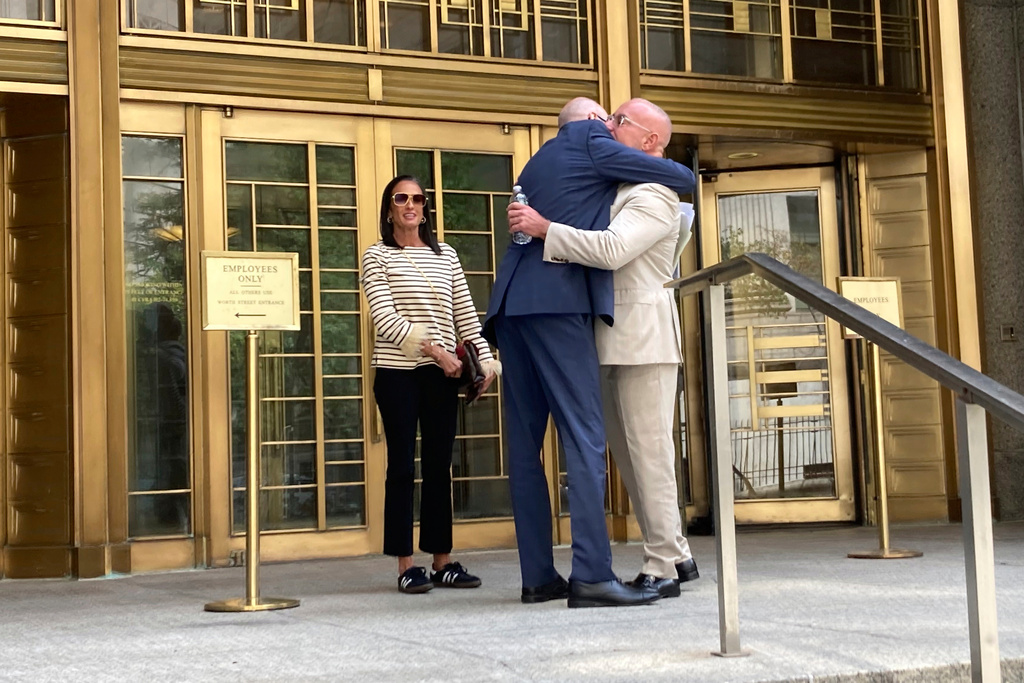 Prominent Miami defense attorney David Macey, with his wife, embraces his attorney after prosecutors agreed to drop criminal charges against him in a long running bribery case involving two former DEA supervisors outside the Manhattan federal court Thursday, Aug. 28, 2025, in New York. (AP Photo/Jake Offenhartz)