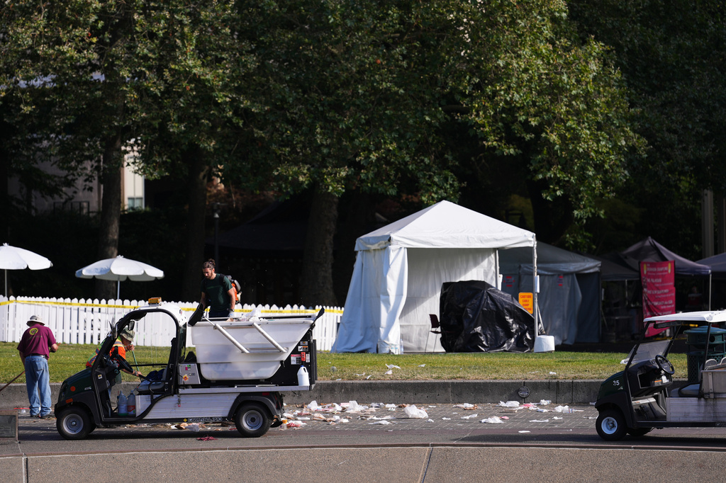 Workers clean up the day after a shooting at Seattle Center during the Bite of Seattle food festival, Monday, July 27, 2026, in Seattle. (AP Photo/Lindsey Wasson)