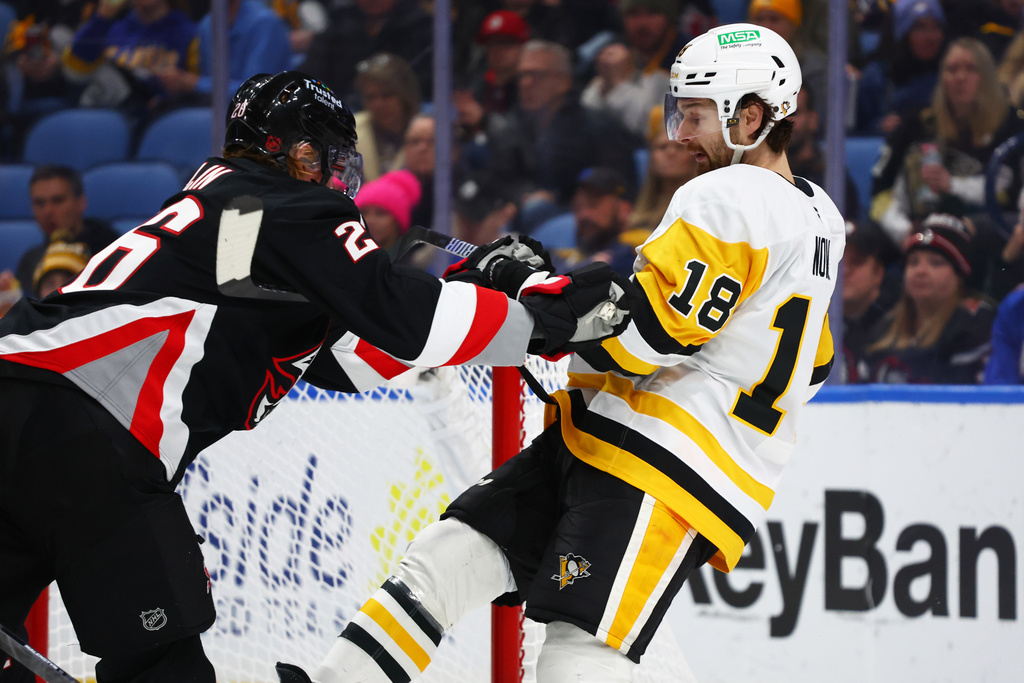 Pittsburgh Penguins center Tommy Novak (18) is stick checked by Buffalo Sabres defenseman Rasmus Dahlin during the second period of an NHL hockey game, Thursday, Feb. 5, 2026, in Buffalo, N.Y. (AP Photo/Jeffrey T. Barnes)