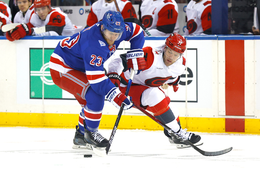 New York Rangers defenseman Adam Fox (23) and Carolina Hurricanes left wing Taylor Hall (71) battle for the puck during the first period of an NHL hockey game, Tuesday Nov. 4, 2025, in New York. (AP Photo/Noah K. Murray)