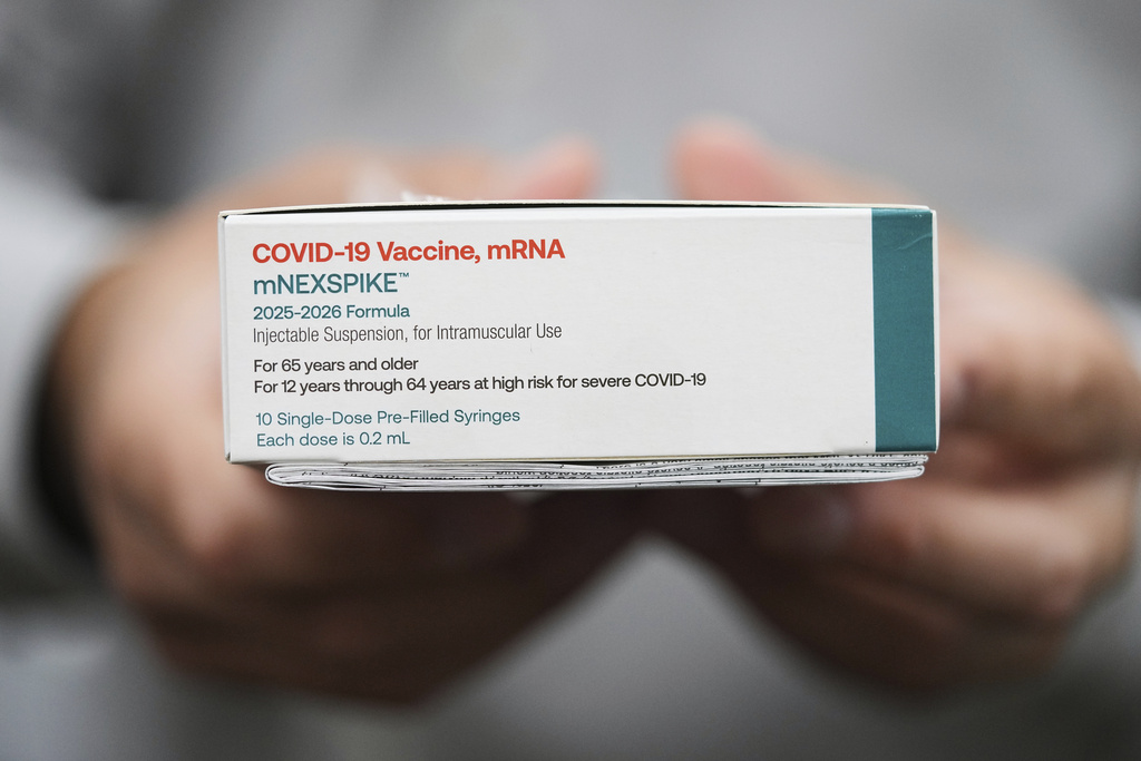 Co-owner Marc Ost at Eric's Rx Shoppe holds a box of COVID-19 vaccines as he unpacks a shipment in Horsham, Pa., Tuesday, Sept. 2, 2025. (AP Photo/Matt Rourke)