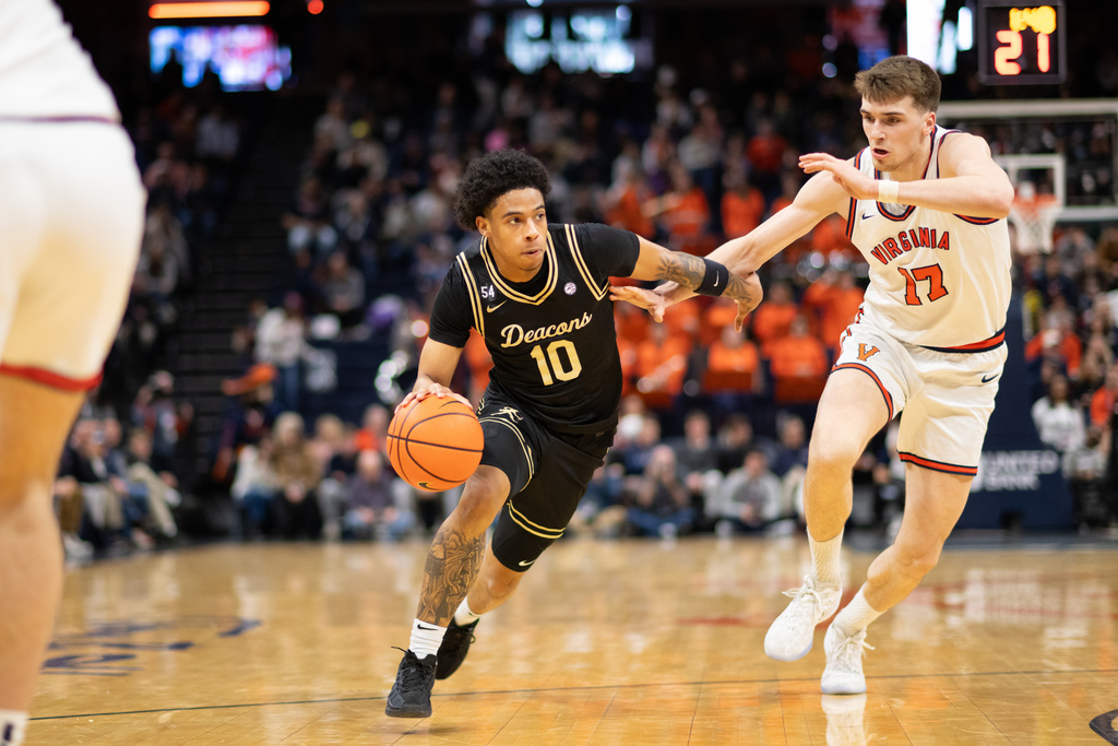 Wake Forest guard Sebastian Akins dribbles by Virginia center Johann Grünloh (17) during the first half of an NCAA college basketball game, Tuesday, March 3, 2026, in Charlottesville, Va. (AP Photo/Robert Simmons)
