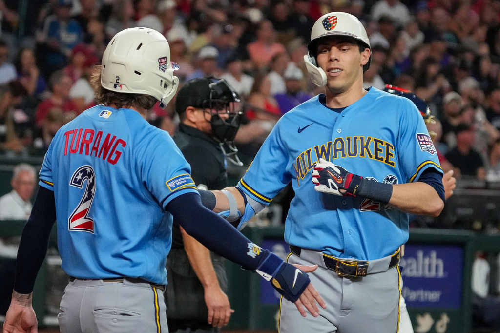 Milwaukee Brewers' Brice Turang, left, greets Christian Yelich, right, after Yelich's two-run home run in the fifth inning during their game against the Arizona Diamondbacks, Saturday, July 4, 2026, in Phoenix. (AP Photo/Darryl Webb)