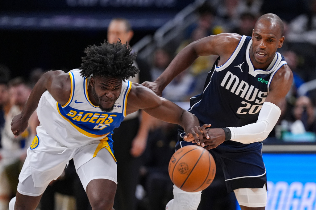 Indiana Pacers forward Jarace Walker (5) and Dallas Mavericks forward Khris Middleton (20) go for a loose ball during the first half of an NBA basketball game in Indianapolis, Sunday, Feb. 22, 2026. (AP Photo/Michael Conroy)