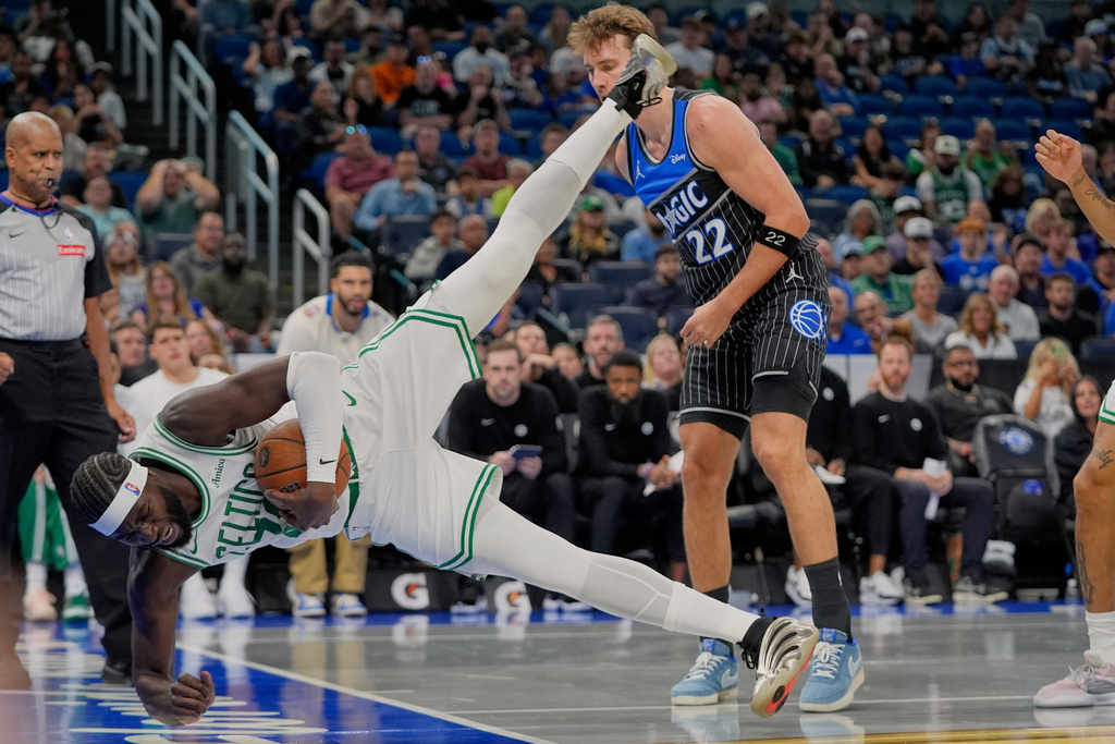 Boston Celtics center Neemias Queta ,left, tries to stop a loose ball from going out of bounds in front of Orlando Magic forward Franz Wagner (22) during the first half of an NBA Cup basketball game, Friday, Nov. 7, 2025, in Orlando, Fla. (AP Photo/John Raoux)