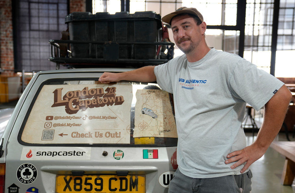 Oliver Jenks poses with the Reliant Robin called "Sheila the three-wheeler" he and Seth Scott drove from London to Cape Town in a bid to break a Guinness World Record for being the first to do the journey in a three-wheeled car in Cape Town, South Africa, Friday, March 20, 2026. (AP Photo/Nardus Engelbrecht)