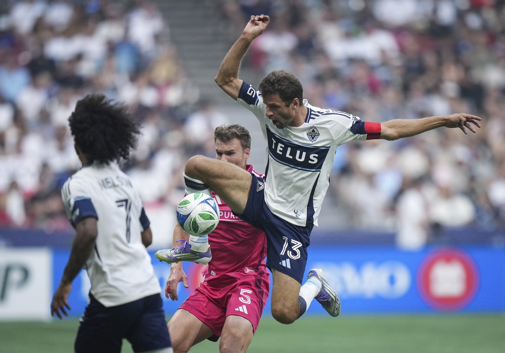 Vancouver Whitecaps Thomas Muller (13) and St. Louis City's Henry Kessler (5) vie for the ball during the first half of an MLS soccer match, in Vancouver, on Saturday, August 23, 2025. (Darryl Dyck/The Canadian Press via AP)