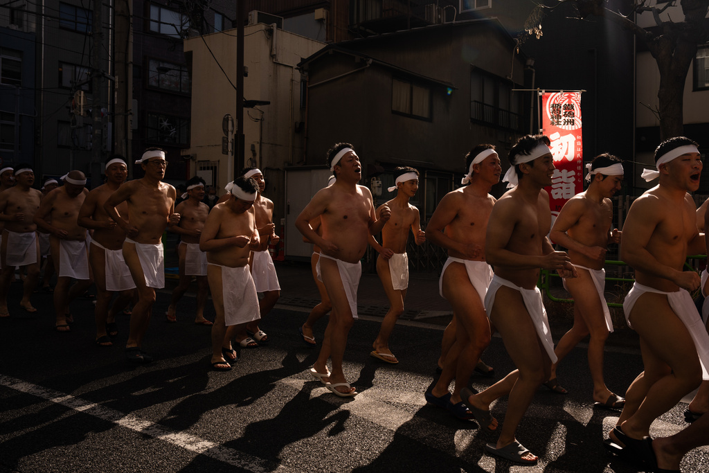Participants prepare to bathe in ice-cold water to purify their souls and pray for good health during a New Year's ritual at Teppozu Inari Shrine in Tokyo, Sunday, Jan. 11, 2026. (AP Photo/Louise Delmotte)