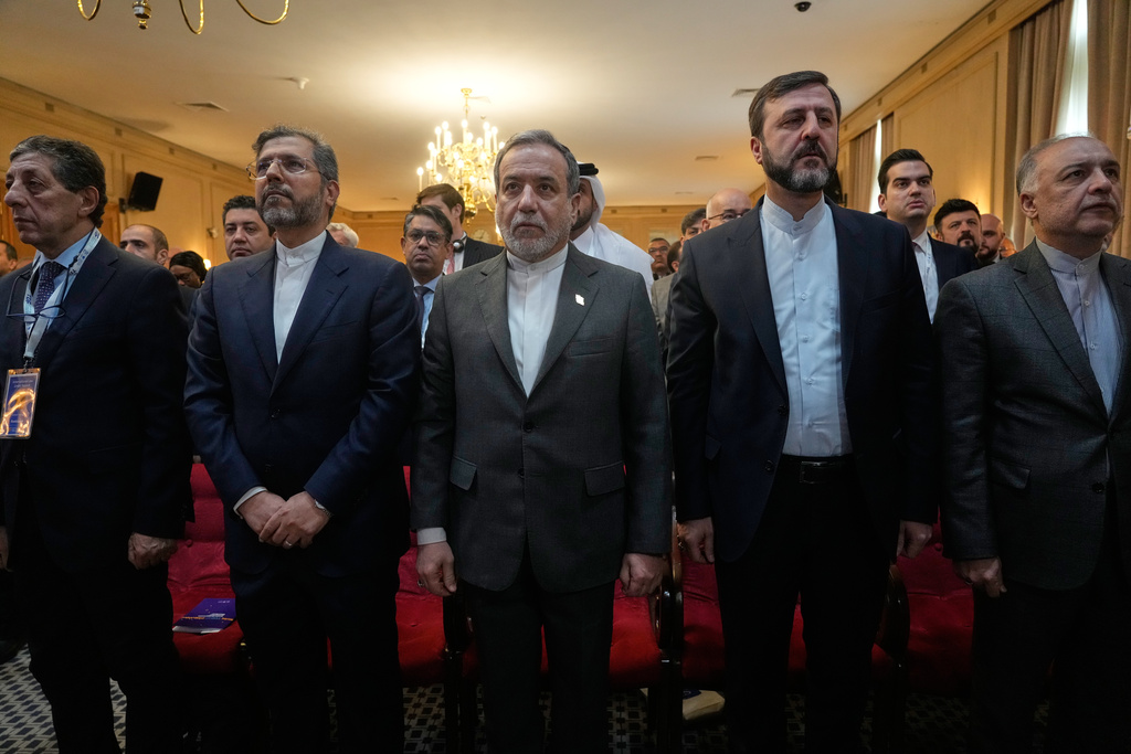 Iranian Foreign Minister Abbas Araghchi, center, stands at attention for the country's national anthem in a conference titled "International Law Under Assault: Aggression and Self-Defense," in Tehran, Iran, Sunday, Nov. 16, 2025. (AP Photo/Vahid Salemi)