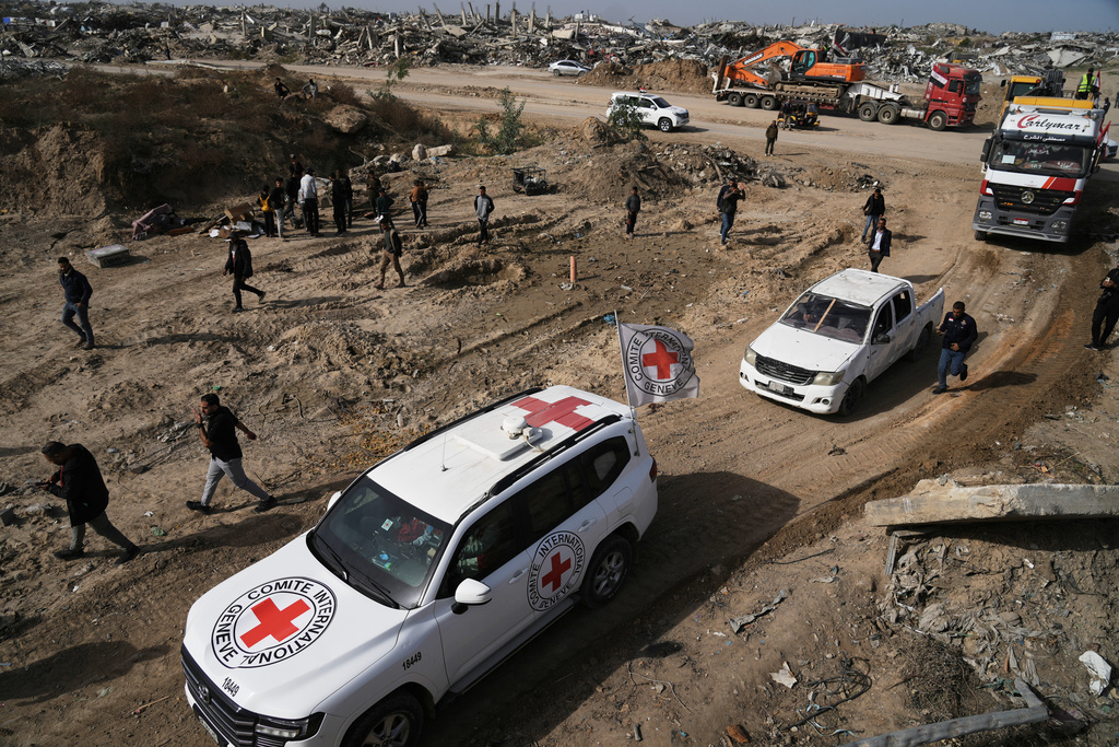 Hamas militants and Egyptian workers accompanied by members of the International Committee of the Red Cross (ICRC) head to Zeitoun neighborhood of Gaza City to search for the remains of the final hostage, Monday, Dec. 8, 2025. (AP Photo/Jehad Alshrafi)