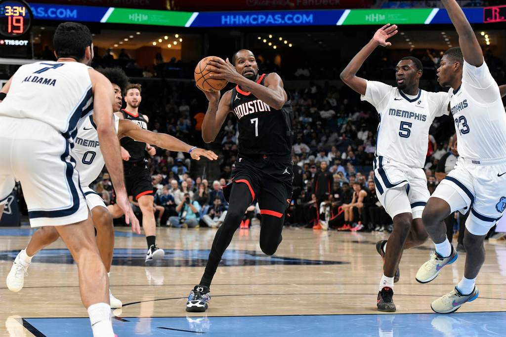Houston Rockets forward Kevin Durant (7) drives between Memphis Grizzlies forward Santi Aldama (7), forward Jaylen Wells (0), guard Vince Williams Jr. (5), and forward Cedric Coward (23) in the first half of an NBA basketball game Wednesday, Nov. 5, 2025, in Memphis, Tenn. (AP Photo/Brandon Dill)