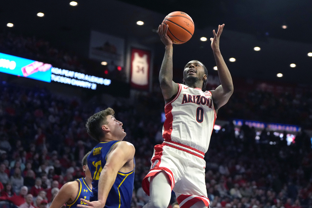 Arizona guard Jaden Bradley (0) goes up to shoot over South Dakota State guard Kalen Garry, front left, during the first half of an NCAA college basketball game, Monday, Dec. 29, 2025, in Tucson, Ariz. (AP Photo/Rick Scuteri)