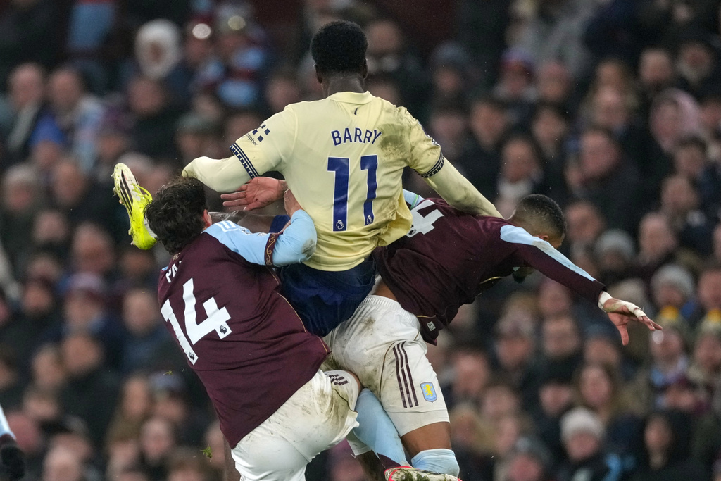 Everton's Thierno Barry, center, Aston Villa's Pau Torres, left, and Aston Villa's Ezri Konsa challenge for the ball during the English Premier League soccer match between Aston Villa and Everton in Birmingham, Sunday, Jan. 18, 2026.(AP Photo/Dave Shopland)