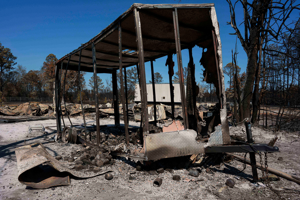A burned trailer sits near a destroyed home as the Brantley Highway 82 fire burns, Thursday, April 23, 2026, near Nahunta, Ga. (AP Photo/Mike Stewart)