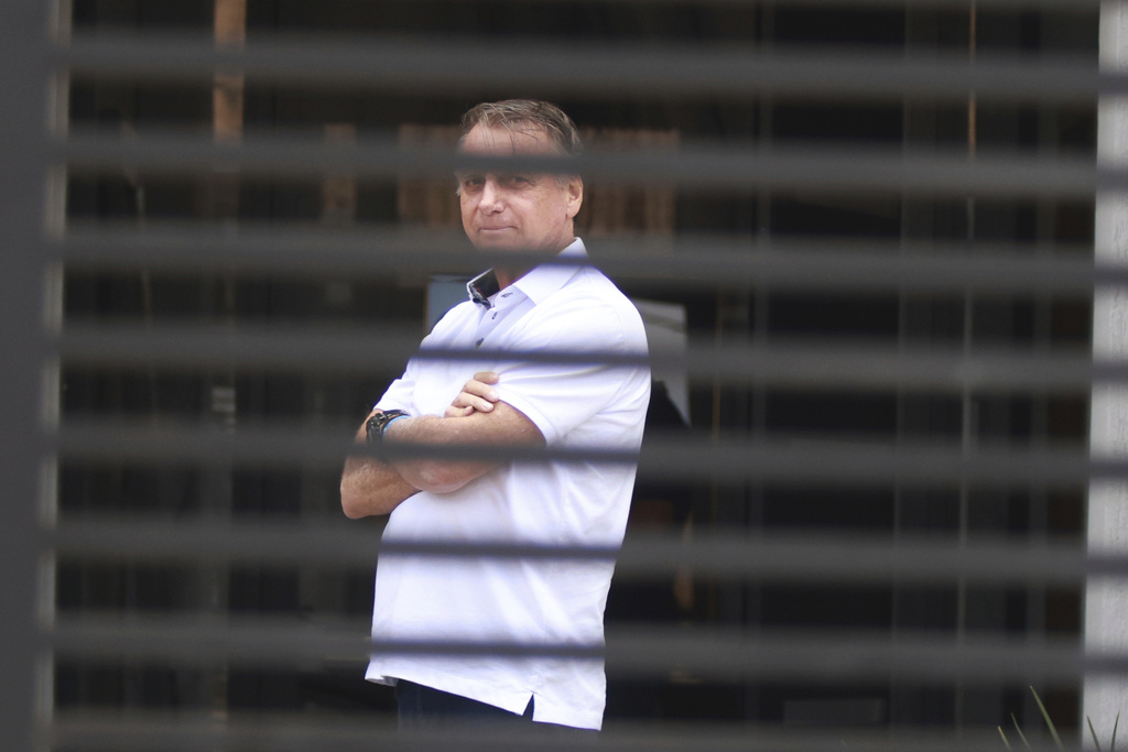 Brazil's former President Jair Bolsonaro stands at the entrance of his home where he is under house arrest in Brasilia, Brazil, Tuesday, Sept. 2, 2025. (AP Photo/Luis Nova)