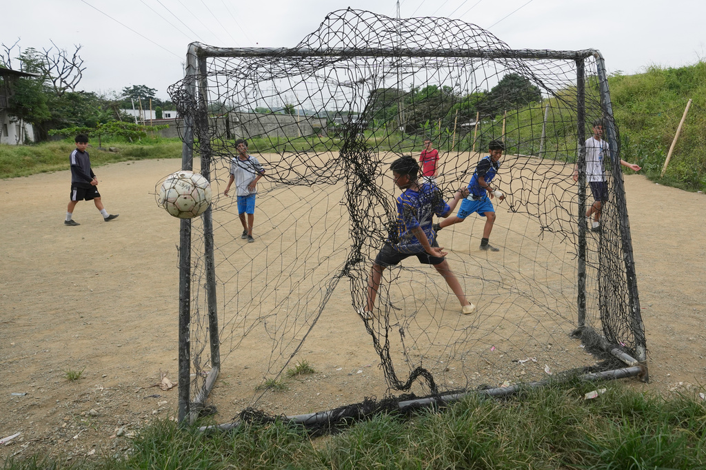 Youth play soccer on a dirt soccer field in the Cooperativa San Francisco neighborhood of Guayaquil, Ecuador, Friday, May 15, 2026. (AP Photo/Dolores Ochoa)