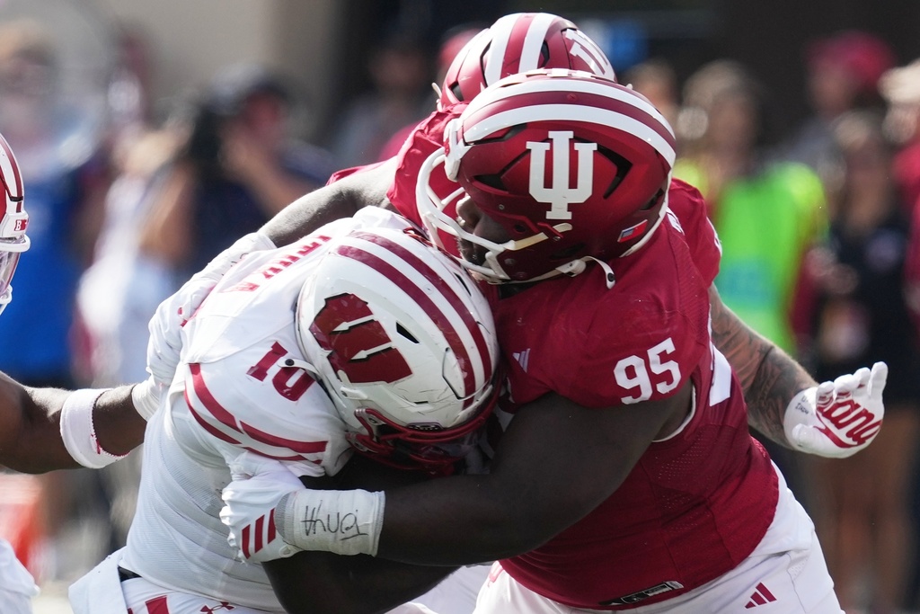 Wisconsin running back Gideon Ituka (10) is tackled by Indiana defensive lineman Tyrique Tucker (95) during the first half of an NCAA college football game, Saturday, Nov. 15, 2025, in Bloomington, Ind. (AP Photo/Darron Cummings)