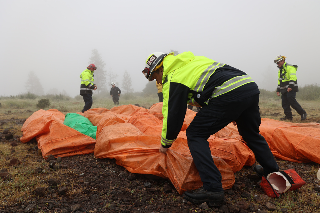 This image provided by Cal Fire shows firefighters practicing deployment of fire shelters used for training during an exercise in Paynes Creek, Calif., on May 5, 2026. (Cal Fire via AP)