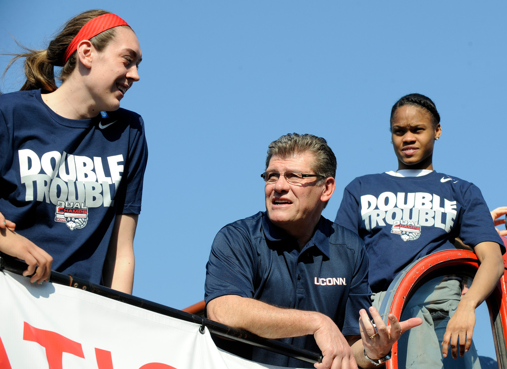 FILE - Connecticut coach Geno Auriemma, center, watches the crowd with Breanna Stewart, left, and Moriah Jefferson during a parade in Hartford, Conn., on Sunday, April 13, 2014, celebrating their recent NCAA national championship. (AP Photo/Fred Beckham)