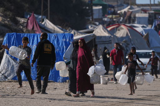 Palestinians carry plastic bottles to collect water in an area of a makeshift tent camp for displaced people along the shore of Nuseirat, in the central Gaza Strip, Wednesday, Oct. 8, 2025. (AP Photo/Abdel Kareem Hana) Palestinians carry plastic bottles to collect water in an area of a makeshift tent camp for displaced people along the shore of Nuseirat, in the central Gaza Strip, Wednesday, Oct. 8, 2025. (AP Photo/Abdel Kareem Hana)