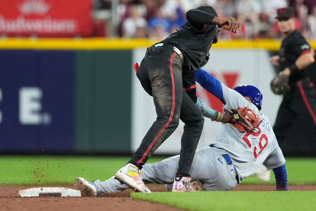Chicago Cubs' Michael Busch, right, is tagged out by Cincinnati Reds shortstop Elly De La Cruz, left, while trying to steal second base to end a baseball game, Friday, Sept. 18, 2026, in Cincinnati. (AP Photo/Kareem Elgazzar)