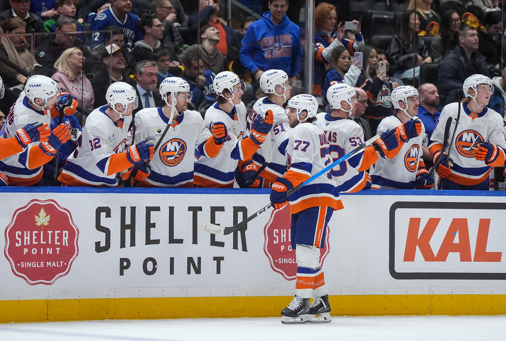 New York Islanders' Tony DeAngelo (77) celebrates his goal against the Vancouver Canucks during the third period of an NHL hockey game, in Vancouver, B.C., Monday, Jan. 19, 2026. (Darryl Dyck/The Canadian Press via AP)