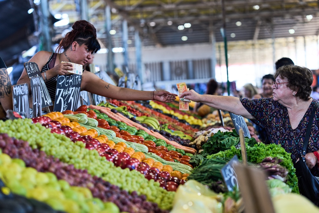 A customer pays for fruit at a greengrocer's stall in Buenos Aires, Argentina, Tuesday, Feb. 10, 2026. (AP Photo/Rodrigo Abd)