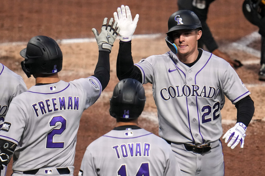 Colorado Rockies' Mickey Moniak (22) is greeted by Tyler Freeman (2) and Ezequiel Tovar (14) as he returns to the dugout after hitting a three-run home run off Pittsburgh Pirates pitcher Mitch Keller during the fifth inning of a baseball game in Pittsburgh, Wednesday, May 13, 2026. (AP Photo/Gene J. Puskar)