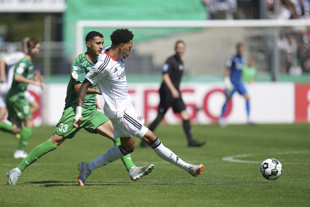 Frankfurt's Nnamdi Collins, front right, and Enger's Ed-Daoudi Ayman, front left, challenge for the ball during the German soccer cup first round match between FV Engers and Eintracht Frankfurt in Koblenz, Germany, Sunday Aug. 17, 2025. (Thomas Frey/dpa via AP)