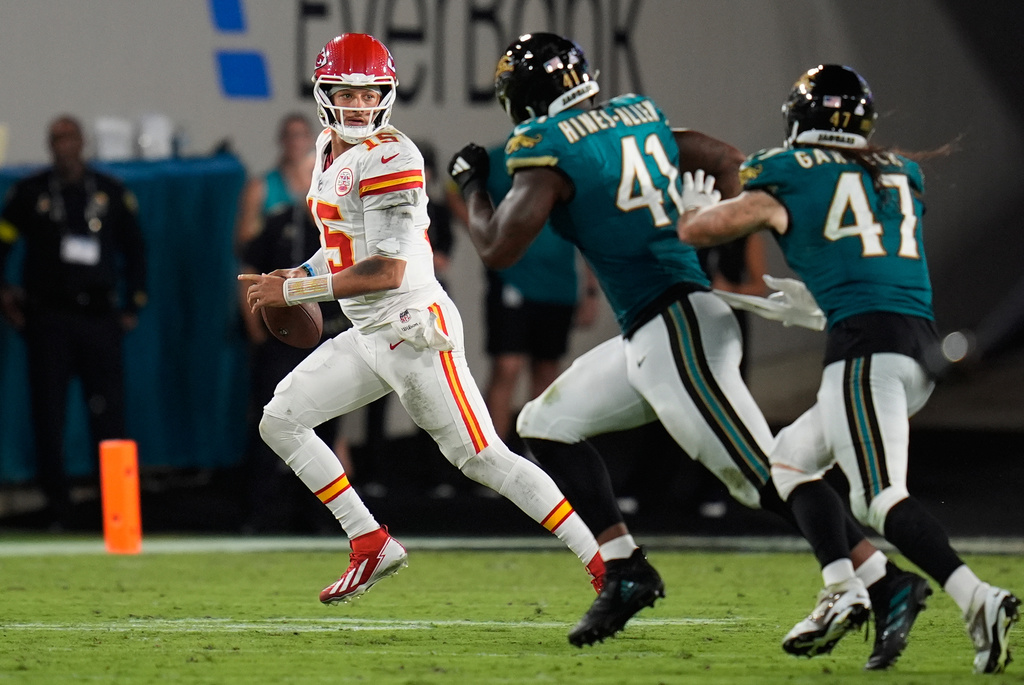 Kansas City Chiefs quarterback Patrick Mahomes (15) looks to pass under pressure from Jacksonville Jaguars defensive end Josh Hines-Allen (41) during the first half of an NFL football game, Monday, Oct. 6, 2025, in Jacksonville, Fla. (AP Photo/John Raoux)